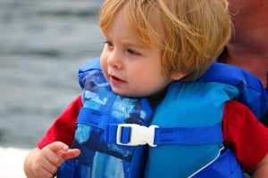 toddler in lifejacket on boat